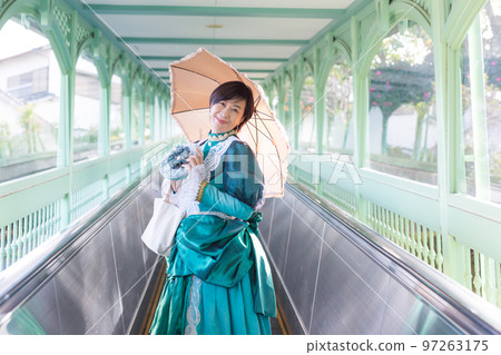 A middle-aged woman wearing a retro costume and enjoying a girls' trip A middle-aged woman wearing a retro costume and enjoying a girls' trip 97263175