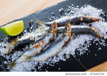 Deliciously dish of anchovy baked in the oven on a pillow of sea salt Deliciously dish of anchovy baked in the oven on a pillow of sea salt 97265534