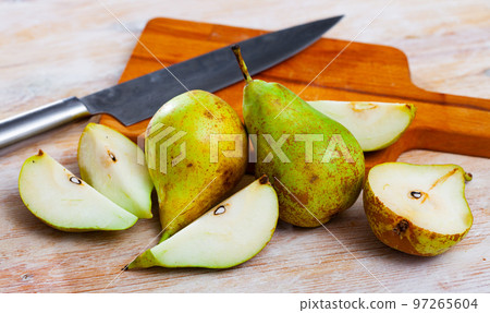 Ripe pears and knife on wooden cutting board Ripe pears and knife on wooden cutting board 97265604