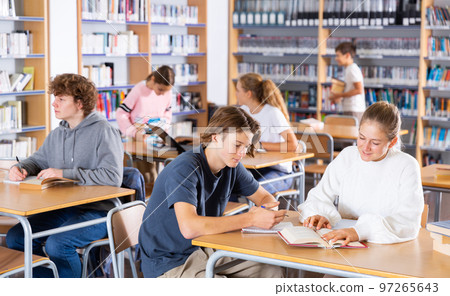 Teenagers spending time in library Teenagers spending time in library 97265643