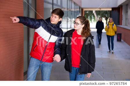 Teen boy pointing at something to girlfriend Teen boy pointing at something to girlfriend 97265784