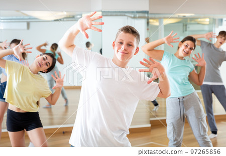 Teenage boy exercising during group dance class Teenage boy exercising during group dance class 97265856