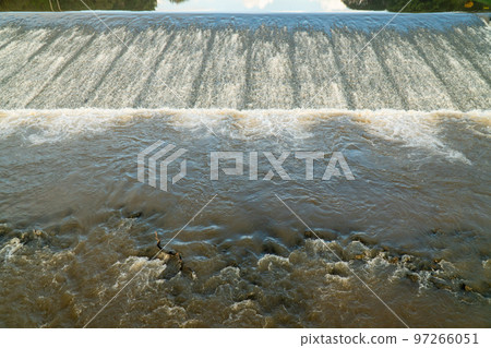 River water flows freely over the top of the weir 97266051
