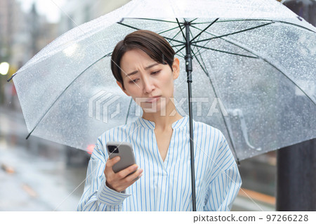 Woman rain umbrella smart phone 97266228
