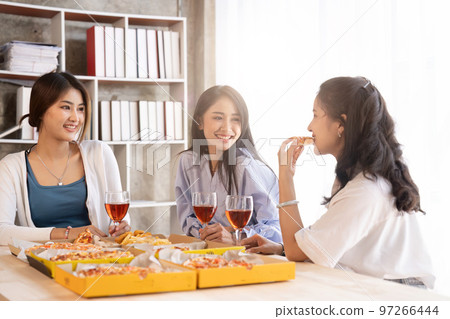 Group of Asian friends gather to celebrate Christmas with champagne and eating pizza at home. Joy of holiday party with friends or colleague concept 97266444