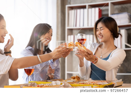 Group of Asian friends gather to celebrate Christmas with champagne and eating pizza at home. Joy of holiday party with friends or colleague concept Group of Asian friends gather to celebrate Christmas with champagne and eating pizza at home. Joy of holiday party with friends or colleague concept 97266457