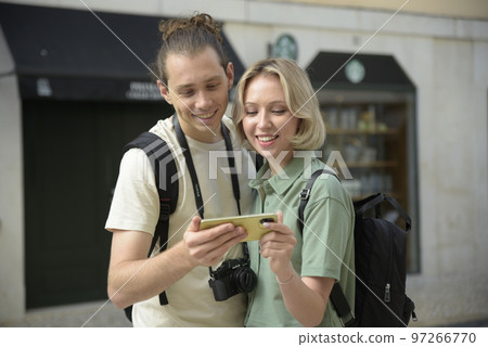 Joyful tourist couple looking at smartphone 97266770