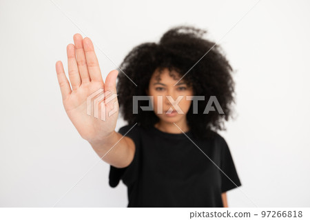 Close-up of stop sign made by serious young woman 97266818