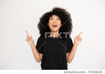 Amazed young woman pointing above at copyspace 97266826