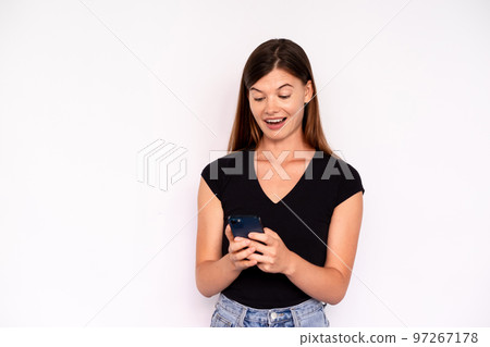Portrait of excited young woman reading message on smartphone 97267178