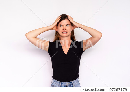 Portrait of worried young woman holding head in hands 97267179