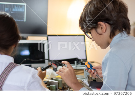 Focused kids geek having robotics class at electronic lab Focused kids geek having robotics class at electronic lab 97267206