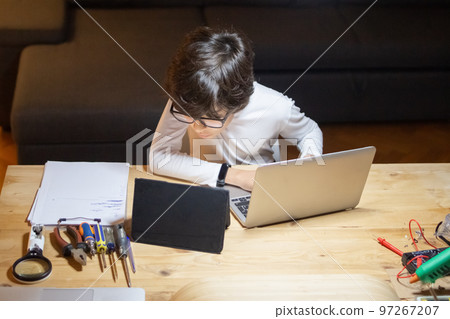 Boy geek in glasses creating new app using laptop and tablet 97267207