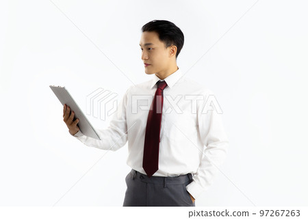 Asian man in white shirt red tie holding tablet computer looking and reading white background.. 97267263