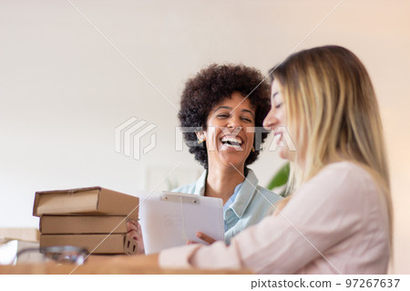 Blackwoman laughing while working at warehouse 97267637