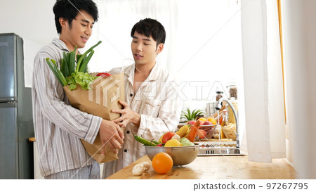 Happy Asian gay couple homosexual cooking together in kitchen prepare fresh vegetable make organic salad healthy food. Asian people happy time smile, laugh in kitchen. Best friend LGBTQ lifestyle Happy Asian gay couple homosexual cooking together in kitchen prepare fresh vegetable make organic salad healthy food. Asian people happy time smile, laugh in kitchen. Best friend LGBTQ lifestyle 97267795