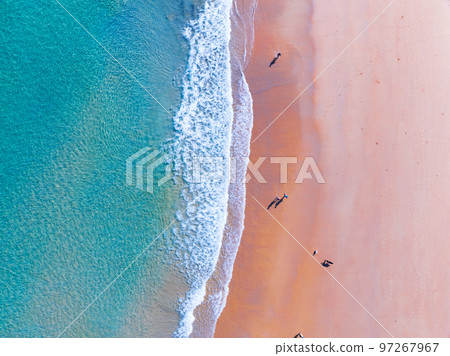 Top view of colorful beach sea surface and people walking on the beach, Shot in the open sea from above,Amazing nature beach background, Turquoise Water surface waves reflecting the Sunlight Top view of colorful beach sea surface and people walking on the beach, Shot in the open sea from above,Amazing nature beach background, Turquoise Water surface waves reflecting the Sunlight 97267967
