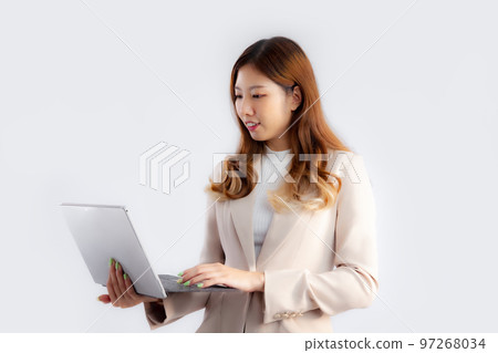 Asian pretty businesswoman in beige color jacket suit using labtop on white background.. Asian pretty businesswoman in beige color jacket suit using labtop on white background.. 97268034
