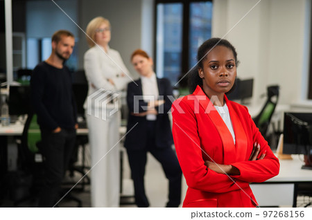 Young african woman is upset because of the ridicule of colleagues. Racial discrimination in the office.  97268156