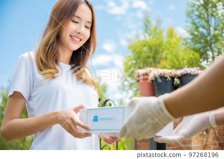 Asian woman sick she receive medication first aid pharmacy box hospital delivery service, Delivery man give medicine drug store to patient female at front home, healthcare medicine online business 97268196