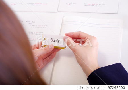 A woman in a school uniform who memorizes words in an English memorization book 97268600