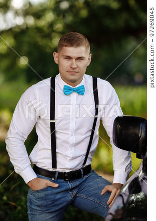 Young man adjusting his bow tie Young man adjusting his bow tie 97269048