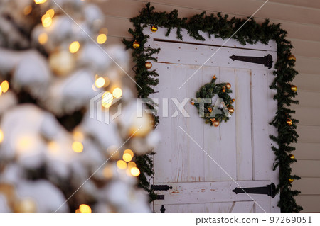 Wooden white house door with green wreath Wooden white house door with green wreath 97269051