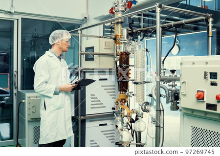 Apothecary scientist recording information from a CBD oil extractor. 97269745