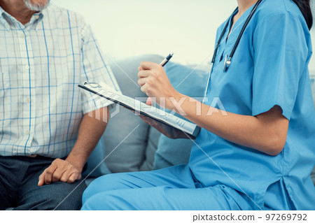 Young female doctor inquires personal data of a contented senior at home. Young female doctor inquires personal data of a contented senior at home. 97269792