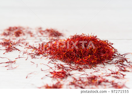 Dried saffron spices on a wooden table, selective focus. Dried saffron spices on a wooden table, selective focus. 97271555