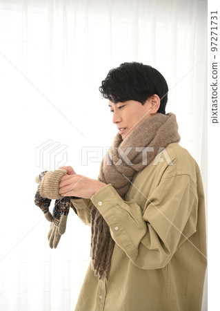 一個戴著圍巾和手套的年輕人 97271731