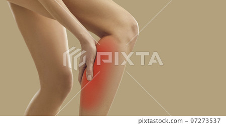 Sick or injured woman experiencing calf muscle pain standing isolated on beige background. 97273537