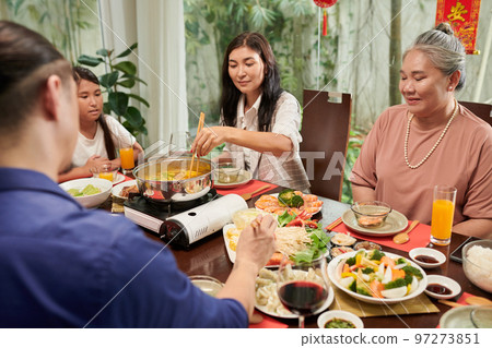 Big family enjoying Chinese New Year celebration and eatng traditional food at home Big family enjoying Chinese New Year celebration and eatng traditional food at home 97273851