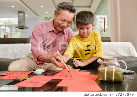 Grandfather teaching grandson calligraphy for Tet celebration Grandfather teaching grandson calligraphy for Tet celebration 97273879