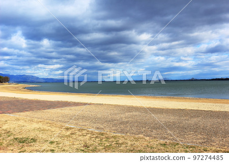 Scenery of the shore of Lake Biwa in the light of the sun covered in winter clouds 97274485