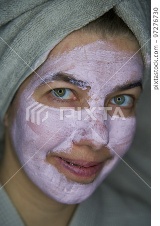 Woman with a towel over your head with face mask of therapeutic clay. Woman with a towel over your head with face mask of therapeutic clay. 97276730