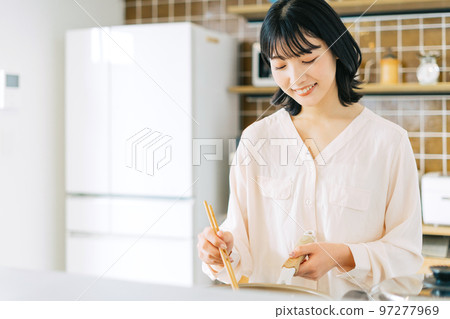 A woman who cooks in the kitchen 97277969