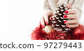 Christmas banner with copy space. Female hands with a red manicure. Manicured woman's hands with Christmas decorations. Winter and Christmas time concept. 97279443