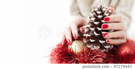 Christmas banner with copy space. Female hands with a red manicure. Manicured woman's hands with Christmas decorations. Winter and Christmas time concept. Christmas banner with copy space. Female hands with a red manicure. Manicured woman's hands with Christmas decorations. Winter and Christmas time concept. 97279443