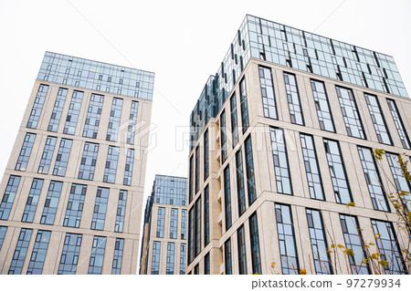Blue beige modern apartment building. Tile and glass facade. View from street, view from below 97279934