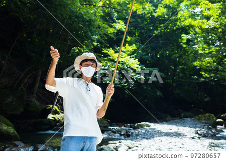 Children enjoying fishing in the mountain stream 97280657