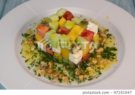 Recipe for sweet and sour salad, feta cheese, cucumber, tomato, kiwi, mango, oil and lemon sauce 97281047