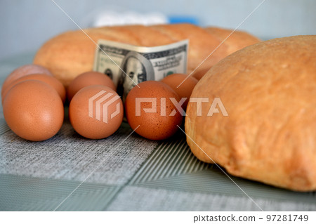 Eggs, bread and banknotes are on the kitchen table. Eggs, bread and banknotes are on the kitchen table. 97281749