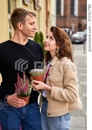 Man and woman holding a purple sempervivum succulent plant and blooming violet heather plant Man and woman holding a purple sempervivum succulent plant and blooming violet heather plant 97281790