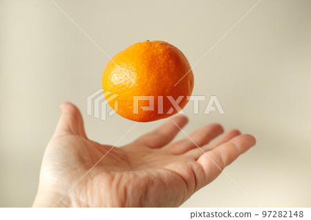 A mandarin orange floating on your hand 97282148