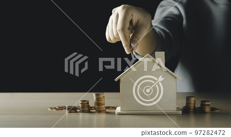 Women hand putting a coin on the model home bank have an icon archery target. with a pile of coins. The concept for the management of financial home loans or money saving for house buying. Women hand putting a coin on the model home bank have an icon archery target. with a pile of coins. The concept for the management of financial home loans or money saving for house buying. 97282472