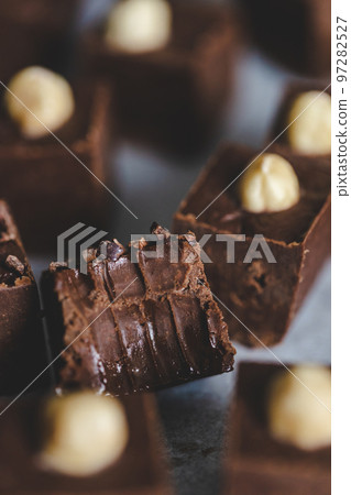 Homemade chocolate fudge with cocoa beans and hazelnuts. 97282527