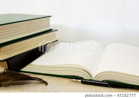 A thick book, a pen and a feather broom 97282777