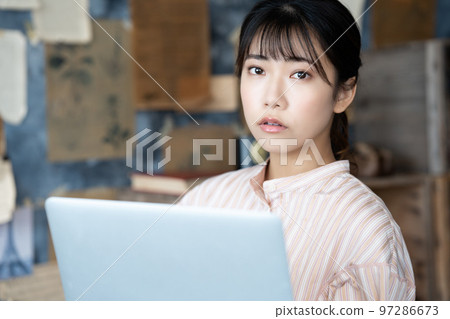 一個女人在別緻的房間裡使用筆記本電腦 97286673