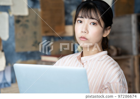 一個女人在別緻的房間裡使用筆記本電腦 97286674